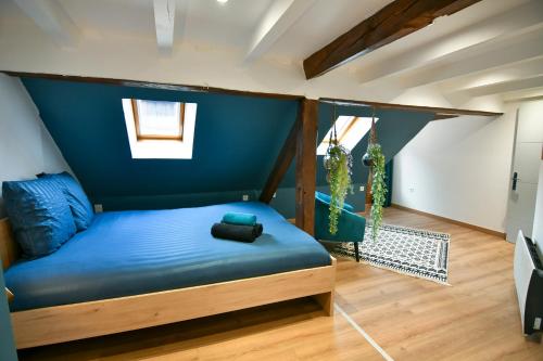 une chambre avec un lit avec un mur bleu dans l'établissement Au Duplex de Jeannala, à Sélestat
