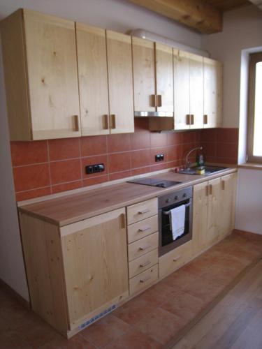a kitchen with wooden cabinets and a sink and a stove at Skalský Mlýn in Lísek