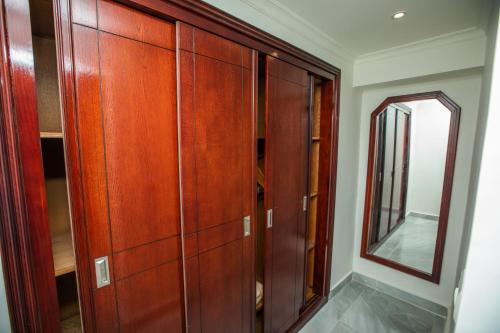 a wooden cabinet in a room with a mirror at AIFU Hotel El Montazah Alexandria in Alexandria