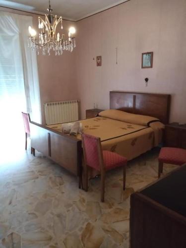 een slaapkamer met een bed en een tafel en stoelen bij LG Appartamento Turistico Giarre in Giarre