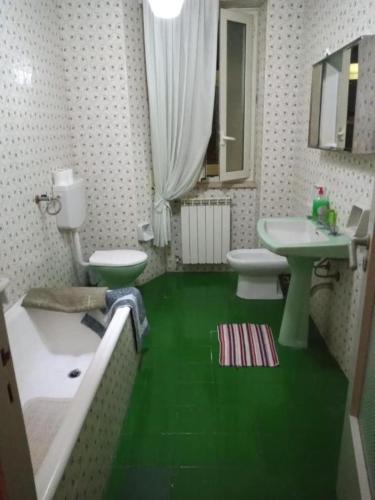 bagno verde con lavandino e servizi igienici di LG Appartamento Turistico Giarre a Giarre