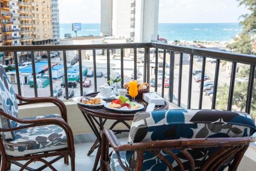 a table with a plate of food on a balcony at AIFU Hotel El Montazah Alexandria in Alexandria