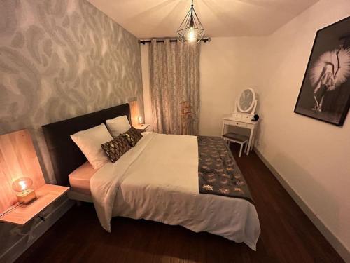 1 dormitorio con 1 cama grande y espejo en Chic and Elegant - Portes de Paris et la Défense, en Bois-Colombes