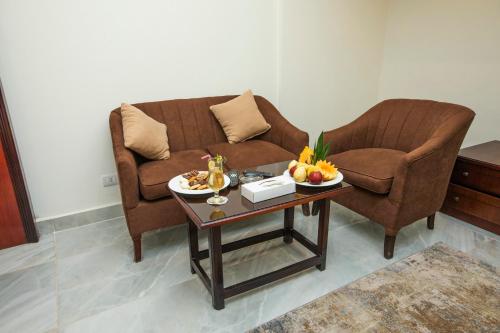 a living room with a couch and a table with fruit on it at AIFU Hotel El Montazah Alexandria in Alexandria
