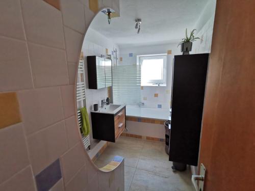 La salle de bains est pourvue d'un lavabo et d'un miroir. dans l'établissement Haus 51,8°, à Bad Nenndorf