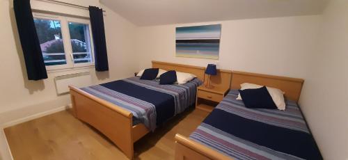 une chambre avec deux lits et une fenêtre dans l'établissement Villa La Plage Pour 7 Personnes A Proximite Du Port De Plaisance, à Capbreton