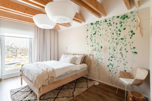 a bedroom with a bed with a wall covered in green leaves at Feng Shui Vila u zámecké zahrady Konopiště in Bystřice