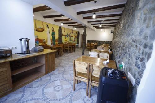 una sala da pranzo con tavolo, sedie e parete di ANGINE Resort Hotel a Vanadzor