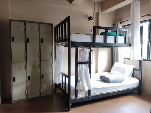 Zimmer mit 2 Etagenbetten und einem Schrank in der Unterkunft Non La Mer Hostel - Bed & Yoga in Ko Lanta
