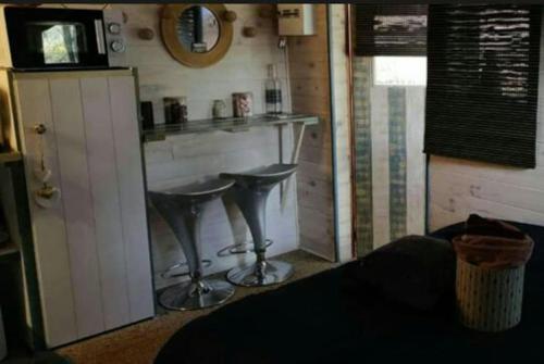 a bar in a room with two stools at Chalet avec spa à Libourne proche St-Emilion in Libourne