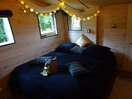 um quarto com uma cama azul com almofadas e luzes em Chalet avec spa à Libourne proche St-Emilion em Libourne