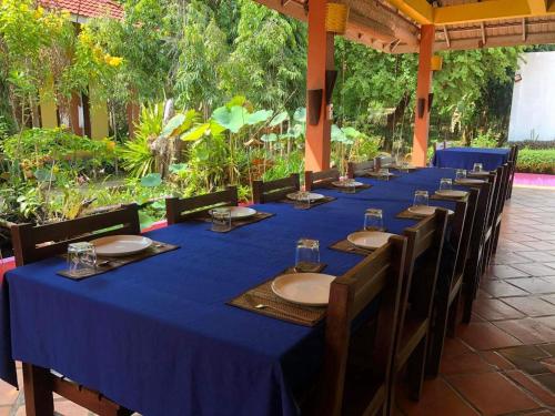 a long table with a blue table cloth and chairs at Memoria Palace & Resort in Pailin