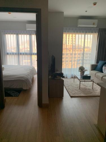 a bedroom with a bed and a living room with a couch at Astra Sky River Condo in Chiang Mai
