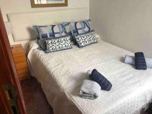 a bed with pillows and towels on top of it at Luminoso y acogedor in Las Palmas de Gran Canaria