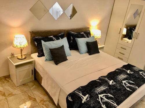 1 dormitorio con 2 camas y almohadas blancas y negras en Charming view old town ap, with free parking en Dubrovnik