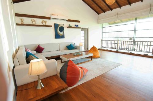 a living room with a couch and a table at River Arc Bolgoda Villa in Panadura