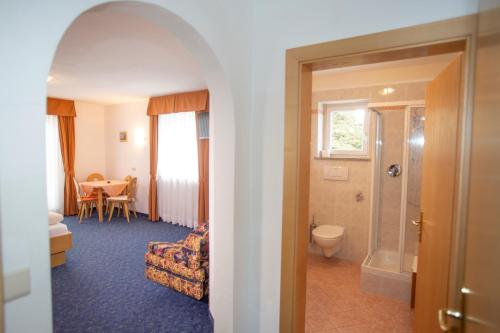 een kamer met een badkamer met een toilet en een tafel bij Gasthof St. Ulrich in Meltina