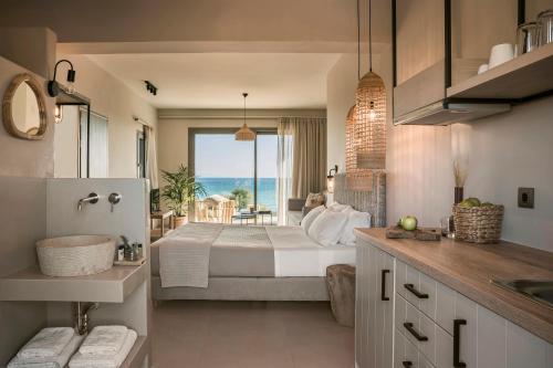 a bedroom with a bed with a view of the ocean at Thalassa Suite-Grand Blue Beach residence in Lixouri