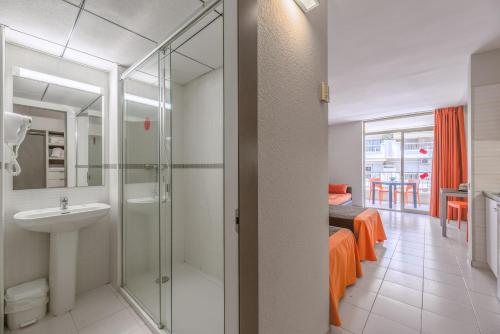 a bathroom with a sink and a shower and a bed at Apartamento bonito en Salou con piscina in Salou