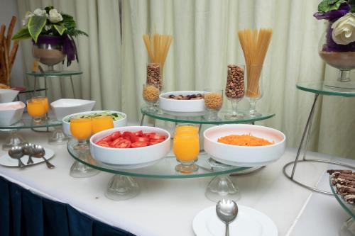 a buffet with bowls of food and glasses of orange juice at AIFU Hotel El Montazah Alexandria in Alexandria