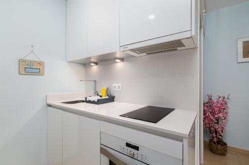 a white kitchen with a sink and a counter top at Beach House Apartment, Playa Malagueta in Málaga