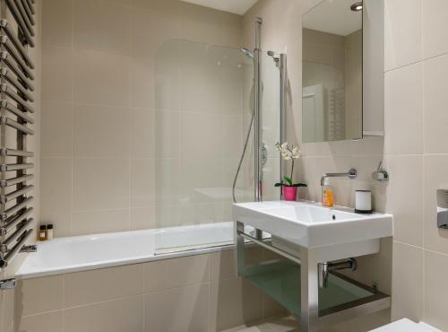 a bathroom with a sink and a shower and a tub at PickThePlace 3-bedroom Portman square in London