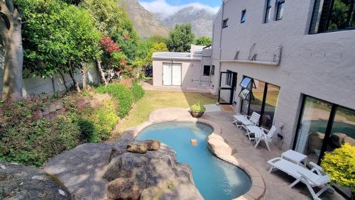a swimming pool in a yard next to a building at Guinea Fowl poolside apartment in Cape Town