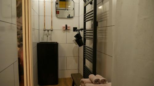 a bathroom with a black and white tiled wall at Maison HOUX in Dominois