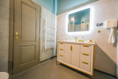 a bathroom with a sink and a mirror and a door at Pensiunea Casa Buna in Gîrbova