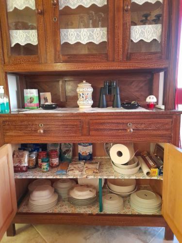 a wooden cabinet filled with dishes and plates at Appartamento Sofia - Nord Sardegna - Badesi in Badesi