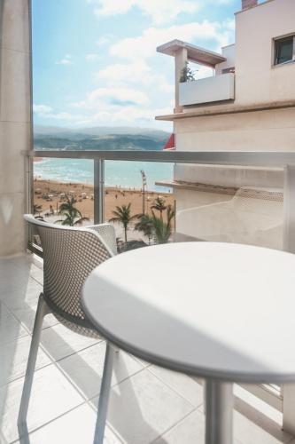 a table and chairs on a balcony with a view of the beach at Hotel Aloe Canteras in Las Palmas de Gran Canaria