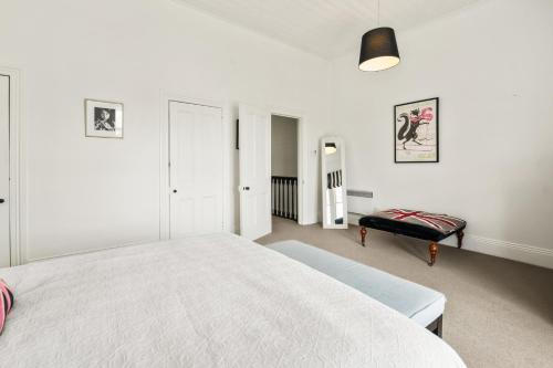 een witte slaapkamer met een groot bed en een bank bij Ports Keep - Napier Holiday Home in Napier
