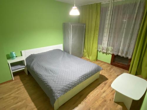 a bedroom with a bed and a table and a window at J&Z Rooms in Burgas