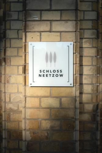 a sign on the side of a brick wall at Hotel Schloss Neetzow in Neetzow