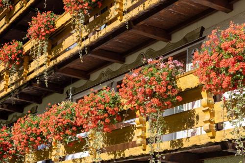 a bunch of flowers in hanging baskets on a building at Landhaus Perktold in Nesselwängle