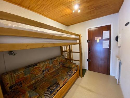 a bedroom with two bunk beds and a door at Boost Your Immo Les Deux Alpes 174 / Le Midi in Les Deux Alpes