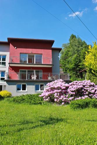 a house with pink flowers in front of it at Apartamenty Kotarz Sauna&Relaks in Brenna