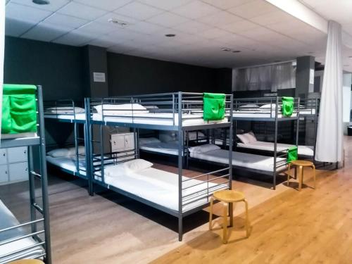 Pokój z 4 łóżkami piętrowymi z zielonymi torbami w obiekcie Albergue Rem w mieście O Pino 