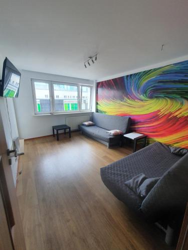 a living room with a colorful mural on the wall at OhMyHome Złota Colors in Warsaw