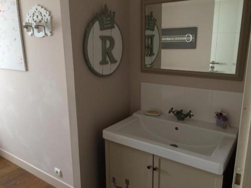 a bathroom with a sink and a mirror at Chambres au calme chez l'habitant in Vertou