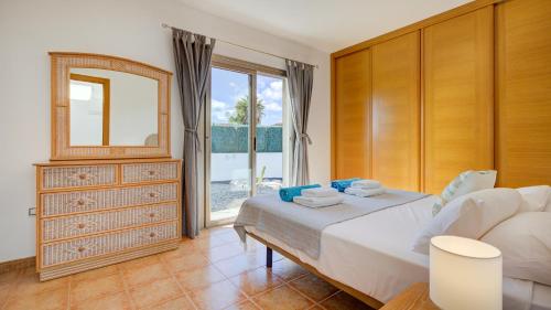 1 dormitorio con cama, espejo y ventana en Villa Melissa, en Costa de Antigua