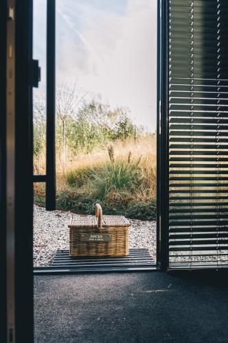 ein Korb, der neben einer Tür auf dem Boden steht in der Unterkunft Haven Lake Village in Kortenhoef
