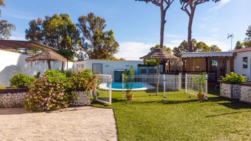 einen Hinterhof mit einem Zaun und einem Pool in der Unterkunft Casa Pinar del Eden Sur in Chiclana de la Frontera