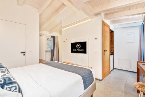 a bedroom with a white bed and a fireplace at Colonna 24 Luxury Room in Portovenere near 5 Terre in Portovenere