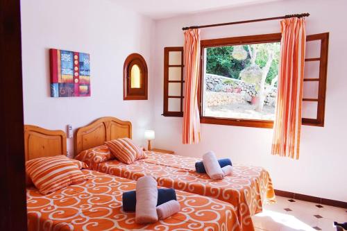 a bedroom with two beds and a window at VILLA MARIA vistas al mar y piscina privada in Son Bou