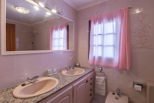 a bathroom with two sinks and a mirror and a toilet at VILLA MARIA vistas al mar y piscina privada in Son Bou