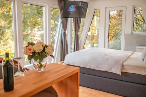sypialnia z łóżkiem i stołem z wazonem kwiatów w obiekcie Bungalow im Schwarzwald auf wunderschönem Anwesen w mieście Neubulach