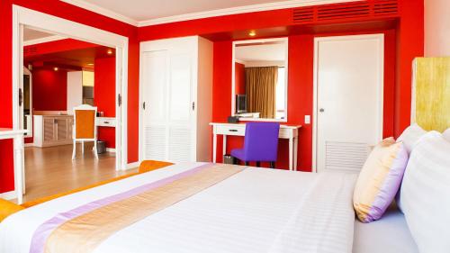 a bedroom with red walls and a large bed at Tongtara Riverview Hotel in Bangkok