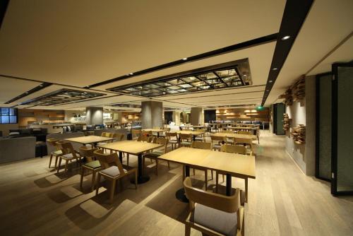 un restaurant avec des tables et des chaises en bois dans un bâtiment dans l'établissement Beijing Qianyuan Hotel, à Pékin