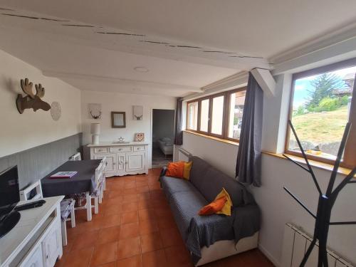 ein Wohnzimmer mit einem Sofa und einem Tisch in der Unterkunft Le saut du cerf (ferme du sotré) in Gérardmer